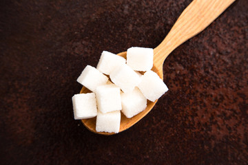 white Sugar cubes on the wooden spoon