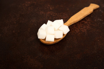 white Sugar cubes on the wooden spoon