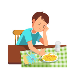 A little boy refusing food, kid does not want to eat. Kid sits at the table and does not want to eating