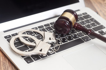 Handcuffs and gavel on laptop