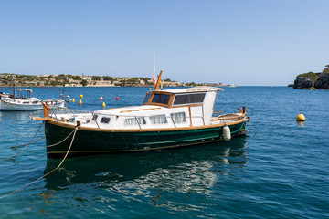 Naklejka na ściany i meble Small wooden boat floating on the sea
