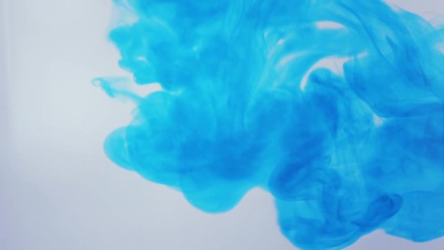 Blue ink dropped into water in slow motion