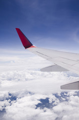 Fototapeta premium The wing of a plane flying over the sky.