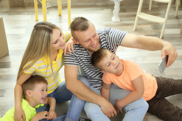 Happy family taking photo with phone in room