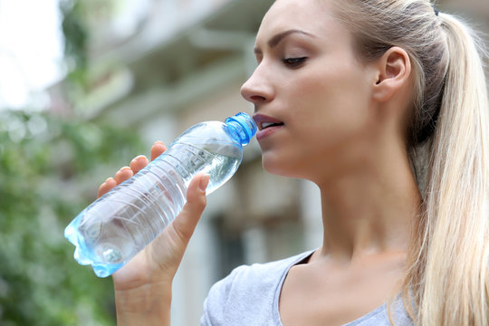Beautiful girl drinking water on street