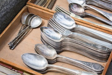 bunch of old silver ware on a flea market