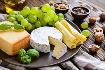 Assorted cheese - smoked gouda, camembert, edam slices with grape and walnuts