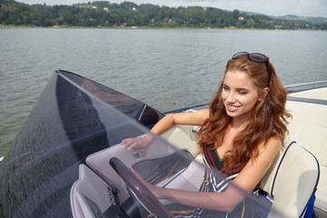 Sommerurlaub - junge Frau, die ein Motorboot fährt