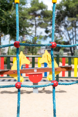 Fototapeta na wymiar Parallel blue ropes of climbing wall at playground