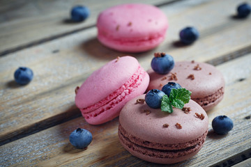 Macaroon with fresh blueberries and chocolate on rustic wooden b