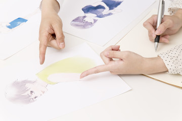イラストの打ち合わせをする若いクリエイターの手元