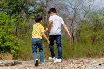 Two Boy walking on the rocky land.