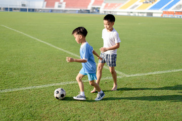 Obraz premium Boy play football on the lawn
