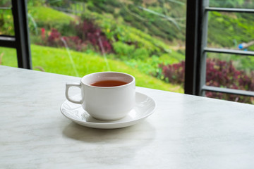 White cup of tea on white marble table in tea shop