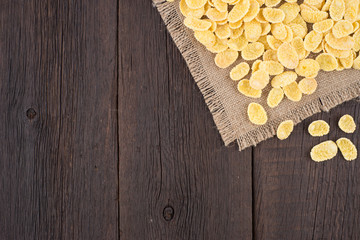 Corn flakes on old wooden table.
