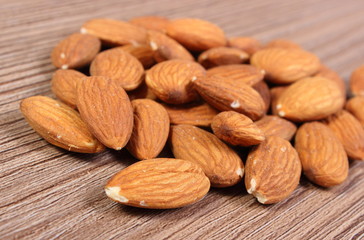 Heap of almonds on wooden background