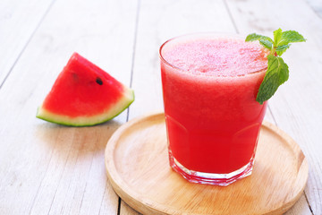 Close up of a glass of healthy water melon smoothie with wooden background.