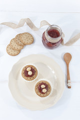 Desayuno con mermelada de fresa, galletas y queso fresco, fondo blanco