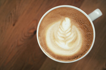 cup of cappuccino on wood table with latte art