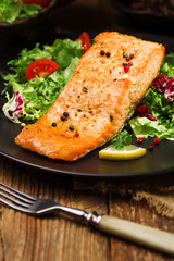 Baked salmon served with fresh vegetables.