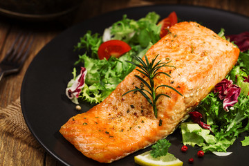 Baked salmon served with fresh vegetables.