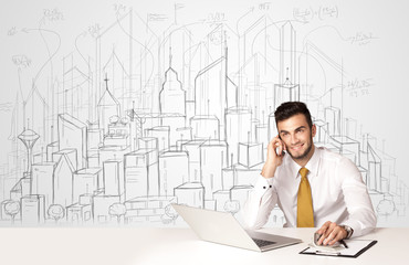 Businessman sitting at the white table with hand drawn buildings