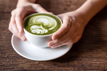 hand holding matcha green tea latter 