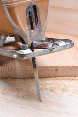 Electric jigsaw with wooden board close up