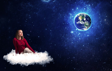 Fototapeta na wymiar Woman sitting on cloud looking at planet earth