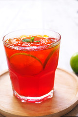 Close up of lime iced tea on a wooden plate.