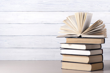 Open book, hardback books on wooden table. Education background. Back to school. Copy space for text.