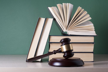 Law concept - Book with wooden judges gavel on table in a courtroom or enforcement office.