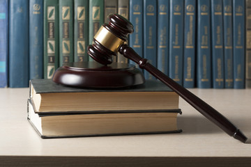 Law concept - Book with wooden judges gavel on table in a courtroom or enforcement office.