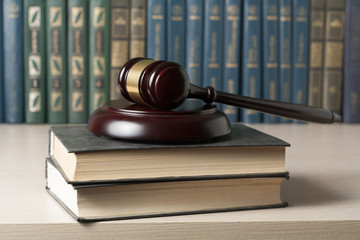 Law concept - Book with wooden judges gavel on table in a courtroom or enforcement office.