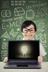Adorable girl with laptop and lightbulb