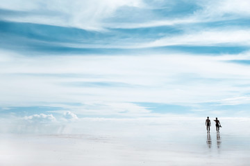 A walk through the heavens . Silhouettes of people on the beach