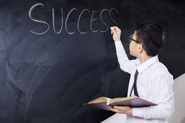 Schoolboy holds book with text of Success