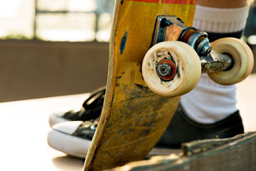 Young man holding a skateboard at sunset