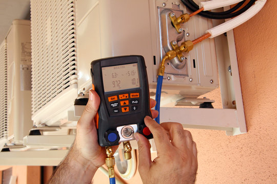 Instalador verificando el compresor de aire acondicionado