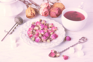 Obraz na płótnie Canvas Tea and tea rose flowers on table closeup