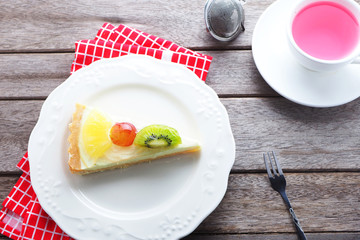 Top view of tropical fruit pie pastry on white plate with summer tea..