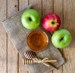 Honey and apples on wood deck for Rosh Hashanah celebration. Jewish New Year Holiday.