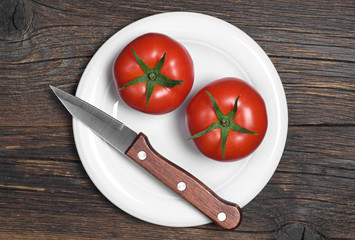 Two tomatoes and knife