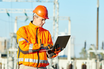 Service engineer working with laptop at heat electric power stat