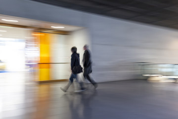 Obraz premium People stream in modern interior, motion blur