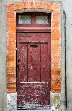 old vintage decaying wooden door facade with brick wall frame
