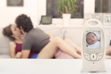 Couple enjoying free time while their newborn is sleeping on the monitor