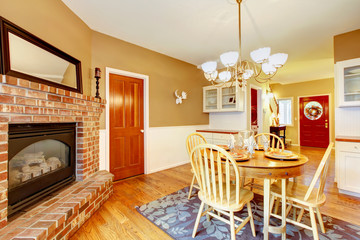 American farm house breakfast dining room area with brick fireplace.