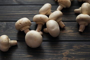 Fresh champignon mushrooms on wooden table