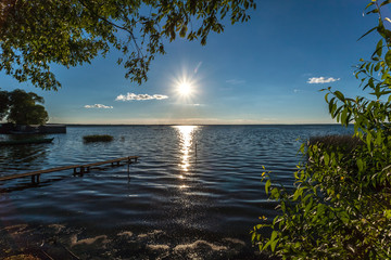Fototapeta na wymiar Solar path to Pleshcheevo coast of the lake in Pereslavl Zalessky